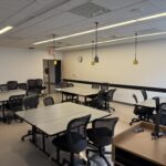 Image taken from the front of the room showing clusters of tables and chairs.