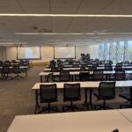 Photo of a classroom looking towards the front of the room showing a two projector screen system.