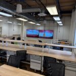 Image from back of the classroom showing the front of the classroom with two large TV displays.