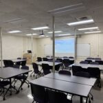View of the classroom from the back of the room showing clusters of tables.