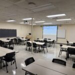 View of the classroom from the back showing clusters of tables.