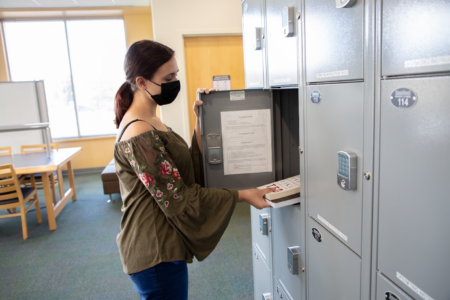 photo of woman placing items in locker
