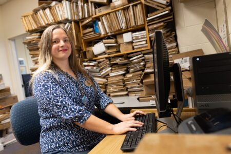 Woman sits at desk with computer