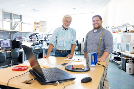 Photo of Dr. Dennis Blanton and Jared Wark with artifacts and a 3D scanner in The Makery.
