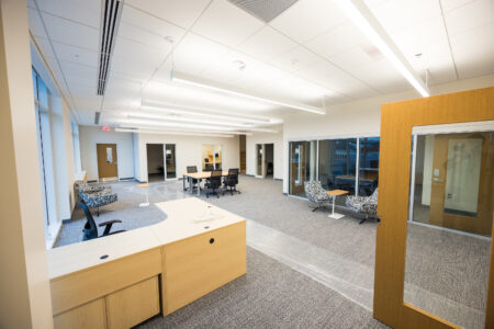 Entrance to office suite with reception desk and meeting table. 