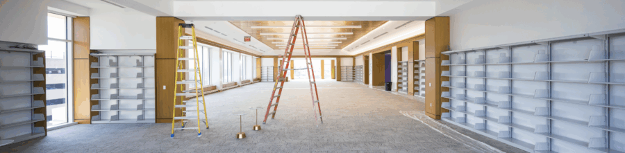 the grand reading room in carrier library as of april 2026. the room is empty other than shelves along the walls and 2 ladders. big windows line the room.