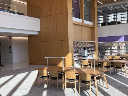 a person browsing the graphic novels shelves in the first-floor double-height spaces in the jones wing of carrier library at jmu