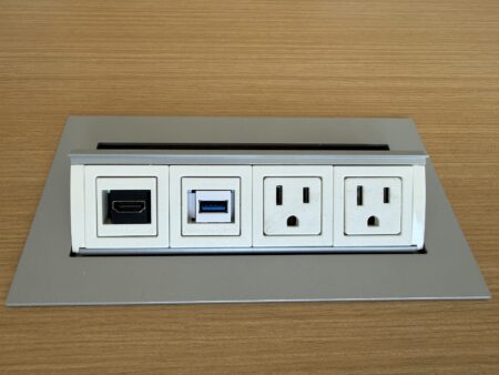 Tabletop connection hub with power outlets, USB-A, and HDMI ports.